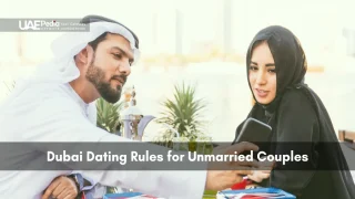 Young Emirati man in kandura and woman in abaya look at smartphone while seated at café.