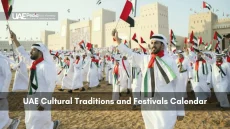 Large group of Emirati men in kanduras wave UAE flags during cultural festival at fort.