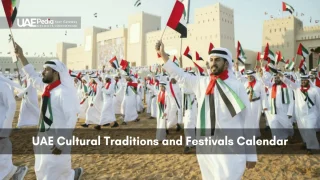 Large group of Emirati men in kanduras wave UAE flags during cultural festival at fort.