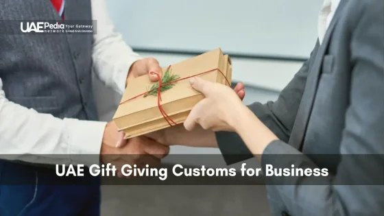Professionals exchanging a traditional gift in a UAE business setting.