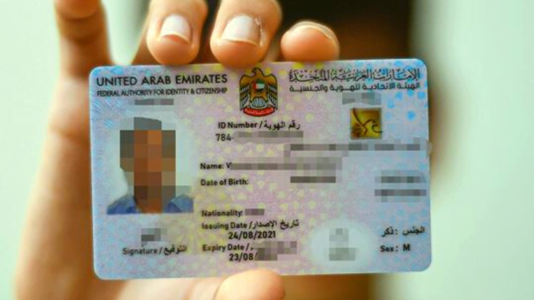 Eligibility to obtain a work permit in the United Arab Emirates and the background of the hand of a person holding the UAE labor card