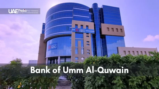 Bank of Umm Al-Quwain building with sleek glass design in a lush setting.