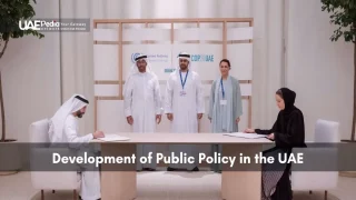 Emirati and global representatives seated at a table signing documents under COP28 UAE signage
