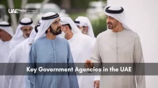 Group of male Emirati ministers and officials standing in rows at a government conference under bright lights