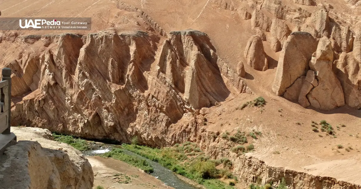 A rocky desert canyon with a river cutting through, surrounded by arid terrain.