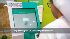 Person using a UAE Pass registration kiosk