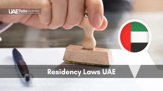 Close-up of a hand using a stamp on paperwork with a UAE flag pin symbolizing residency laws.