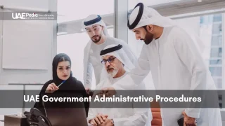 Group of Emirati professionals gathered around a laptop discussing paperwork in an office setting