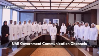 Group of UAE government ministers and officials standing around a modern boardroom table under skylights