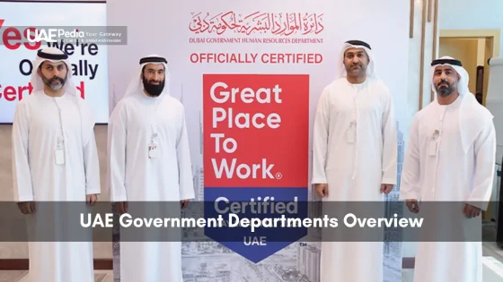 Group of Emirati officials in kanduras standing next to a Great Place to Work certified display by Dubai HR department