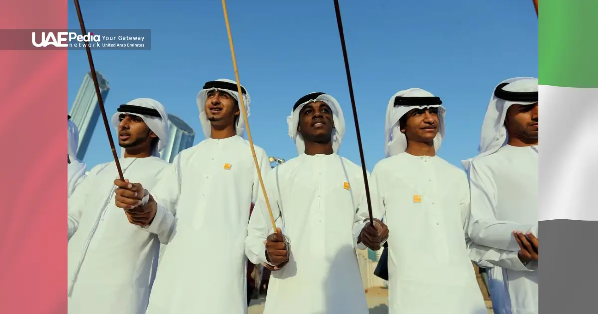 Emirati performers in white attire showcasing a traditional stick dance.