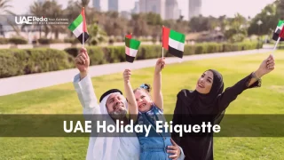 Smiling Emirati family waving UAE flags together in a public park.