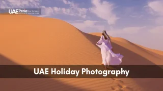 A person in traditional attire walking through the desert sands during a UAE holiday.