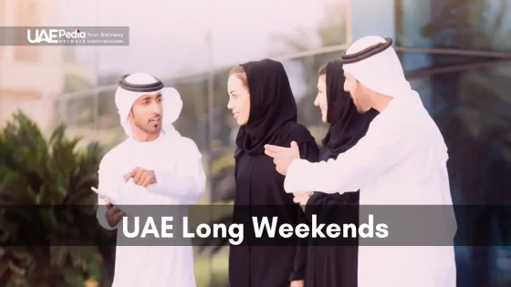 A group of people in traditional attire discussing UAE Long Weekends outdoors.