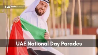 Man dressed in traditional Emirati attire smiling and holding UAE flag.