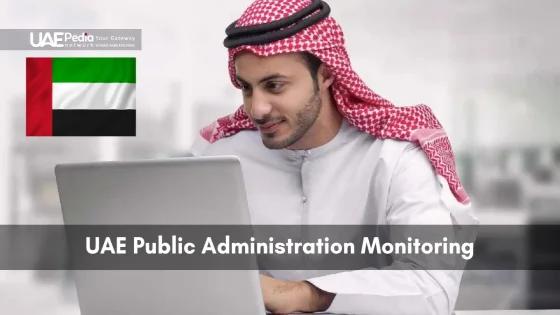 Man wearing keffiyeh focused on laptop with UAE flag in the background.