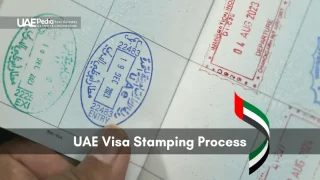 Finger flipping passport page to display UAE entry and exit immigration stamps.