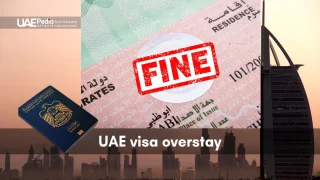 Residency visa page stamped “FINE” in red next to a UAE passport and Dubai skyline backdrop