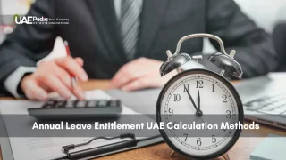 Desk with clock, calculator, and person reviewing UAE leave policies