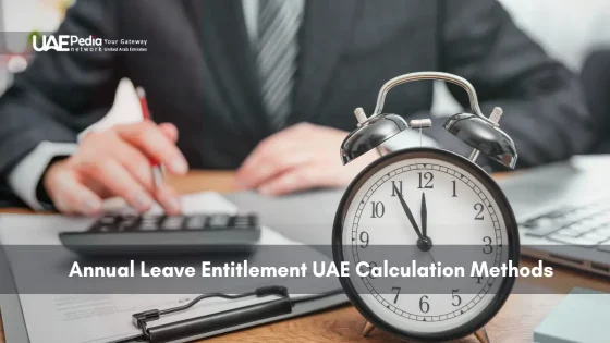 Desk with clock, calculator, and person reviewing UAE leave policies