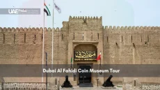 Entrance to the Dubai Al Fahidi Coin Museum with flags and cannons.