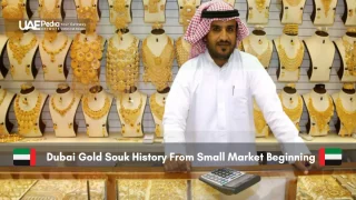 Emirati gold shopkeeper behind counter of jewelry in Gold Souk