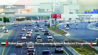 Dubai highway traffic under the Al Mamzar Toll Gate with smart signs