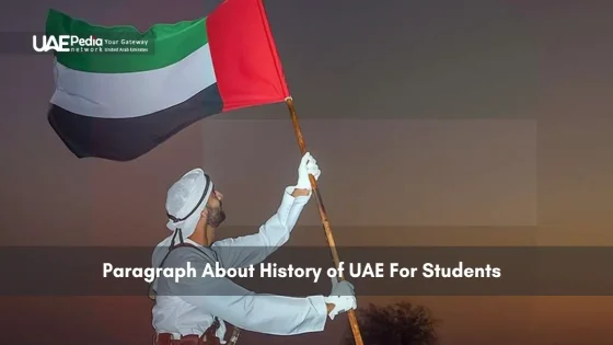 Man in traditional attire holding the UAE flag high