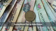 UAE dirham notes and one-dirham coin laid out in a fan shape