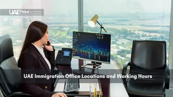 A woman working at an office desk in front of a cityscape.