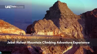Group of climbers ascending Jebel Hafeet mountain at sunset