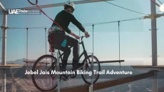 Cyclist on a suspended mountain biking trail in Jebel Jais