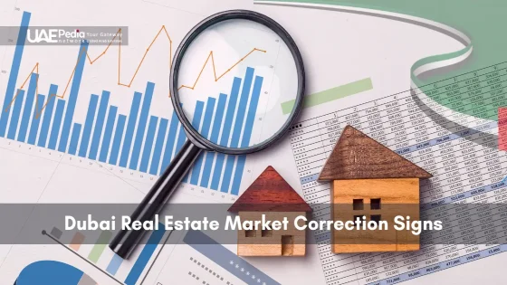 Magnifier over blue bar and orange line graphs beside two wooden house figurines