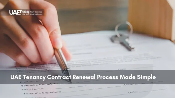 Hand signing tenancy renewal contract with house keys beside