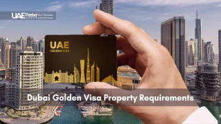 A hand holds a UAE Golden Visa card with Dubai Marina’s skyscrapers reflected in the water.