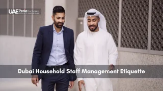 Two men walking outside, one in a business suit and the other in traditional Emirati dress.