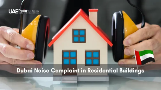 Person fitting earmuffs onto a small house model to represent noise complaints in Dubai residences.