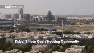 View of desert-style villas and contemporary office towers around a lagoon in Dubai Silicon Oasis.