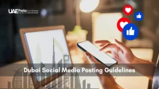 Smartphone and laptop scene with social media icons and Dubai skyline representing posting rules.