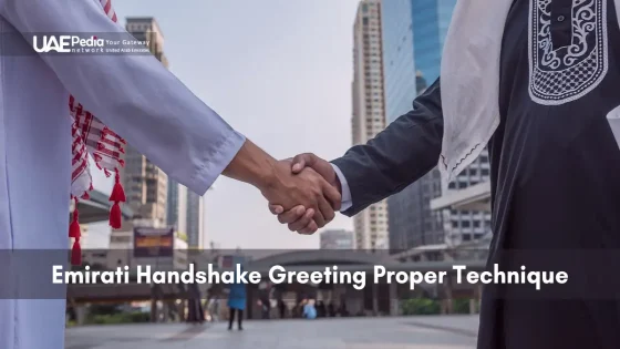 Close-up of two Emirati men performing a traditional handshake greeting in a Dubai urban environment.