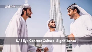 Three men in kanduras talk with Burj Khalifa in the background.