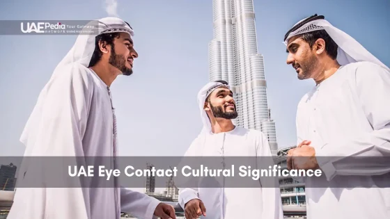 Three men in kanduras talk with Burj Khalifa in the background.