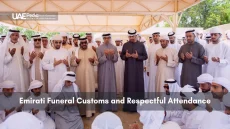 Group of Emirati men in traditional dress at a funeral tent.