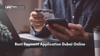 A person using a smartphone to make an online rent payment while holding a credit card near a laptop.