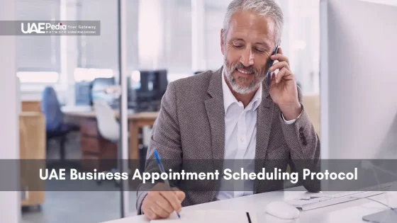A man in a suit takes notes while on a call, arranging a business meeting.